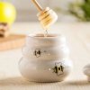 Porcelánová nádoba na med s drevenou naberačkou Porcelánová nádoba na med s drevenou naberačkou