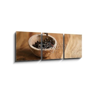 Obraz s hodinami 3D třídílný - 150 x 50 cm - black dry pepper fall into wooden bowl on table Černý suchý pepř spadl do dřevěné misky na stole