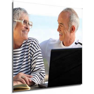 Skleněný obraz 1D - 50 x 50 cm - Senior couple in the garden with laptop and book Senior pár v zahradě s notebookem a knihou – Zbozi.Blesk.cz