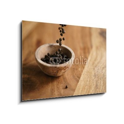 Obraz 1D - 100 x 70 cm - black dry pepper fall into wooden bowl on table Černý suchý pepř spadl do dřevěné misky na stole