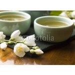 WEBLUX 42047983 Fototapeta plátno Green tea with jasmine in cup and teapot on wooden table Zelený čaj s jasmínem v šálku a konvici na dřevěném stole rozměry 160 x 116 cm – Zboží Mobilmania