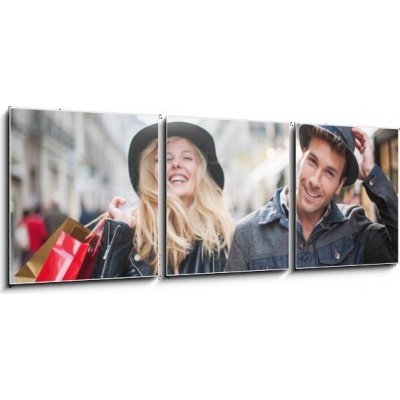 Obraz 3D třídílný - 150 x 50 cm - a trendy young couple wearing hats walking in the city in autum módní mladý pár nosí klobouky chůzi ve městě v podzimní