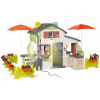 Domček s dvoma kuchynkami Friends House DeLuxe Life Smoby rozšíriteľný a stolíky so slnečníkom s oplotením